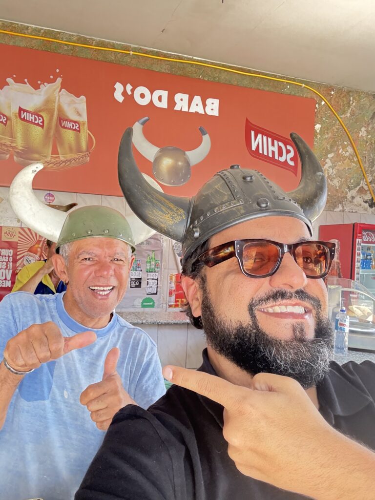 Selfie de Nelson e Thiago Kuin usando capacetes de viking com chifres no Bar do Corno, na Vila Madalena
