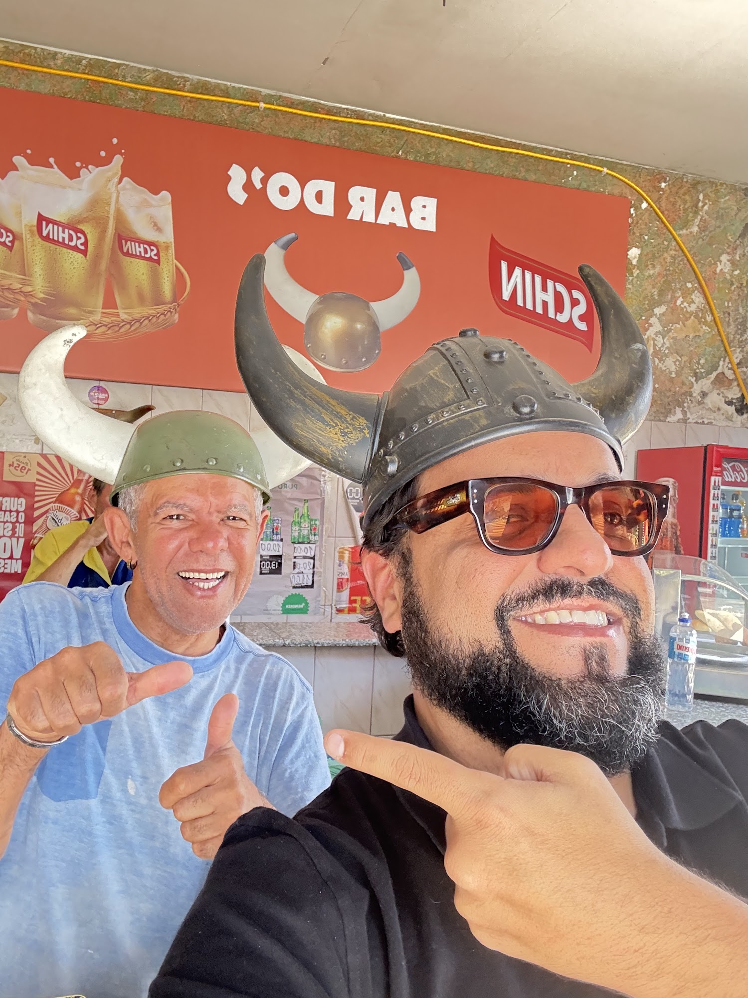 Selfie de Nelson e Thiago Kuin usando capacetes de viking com chifres no Bar do Corno, na Vila Madalena