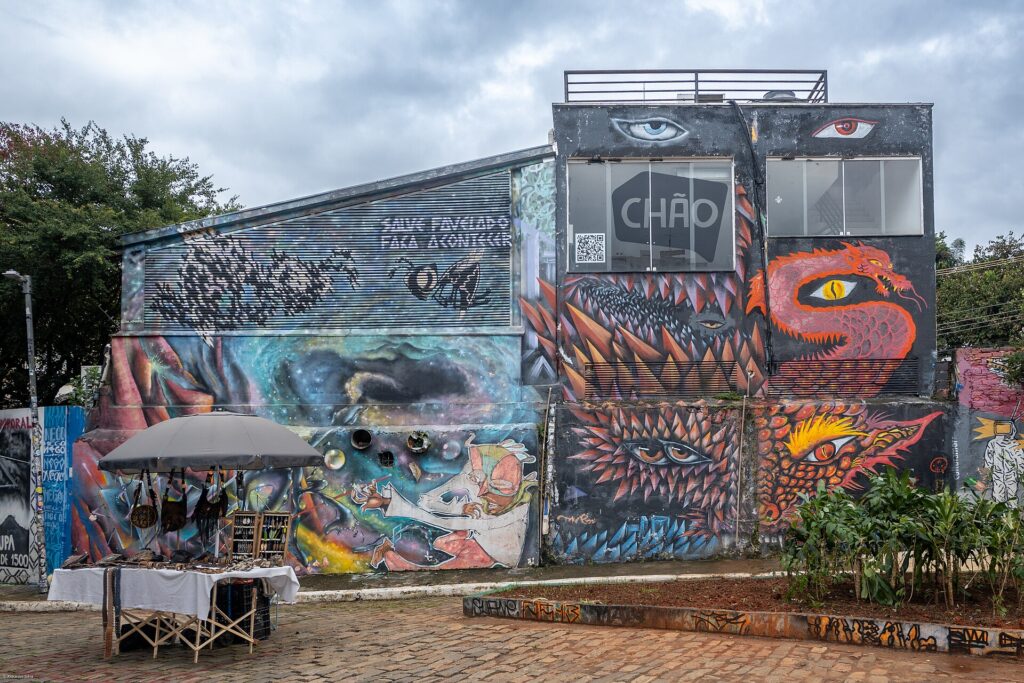 Galpão grafitado no Beco do Batman com barraca de feira em frente