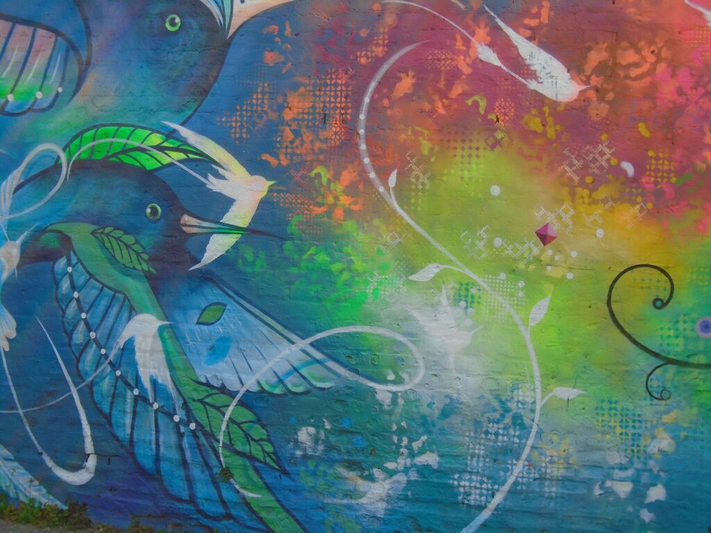 Detalhe de grafite com beija-flor e cores vibrantes no Beco do Batman