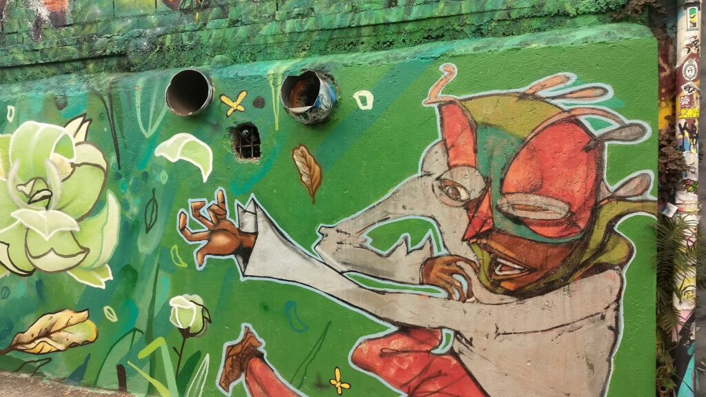 Grafite em fundo verde com personagem de chapéu e flores