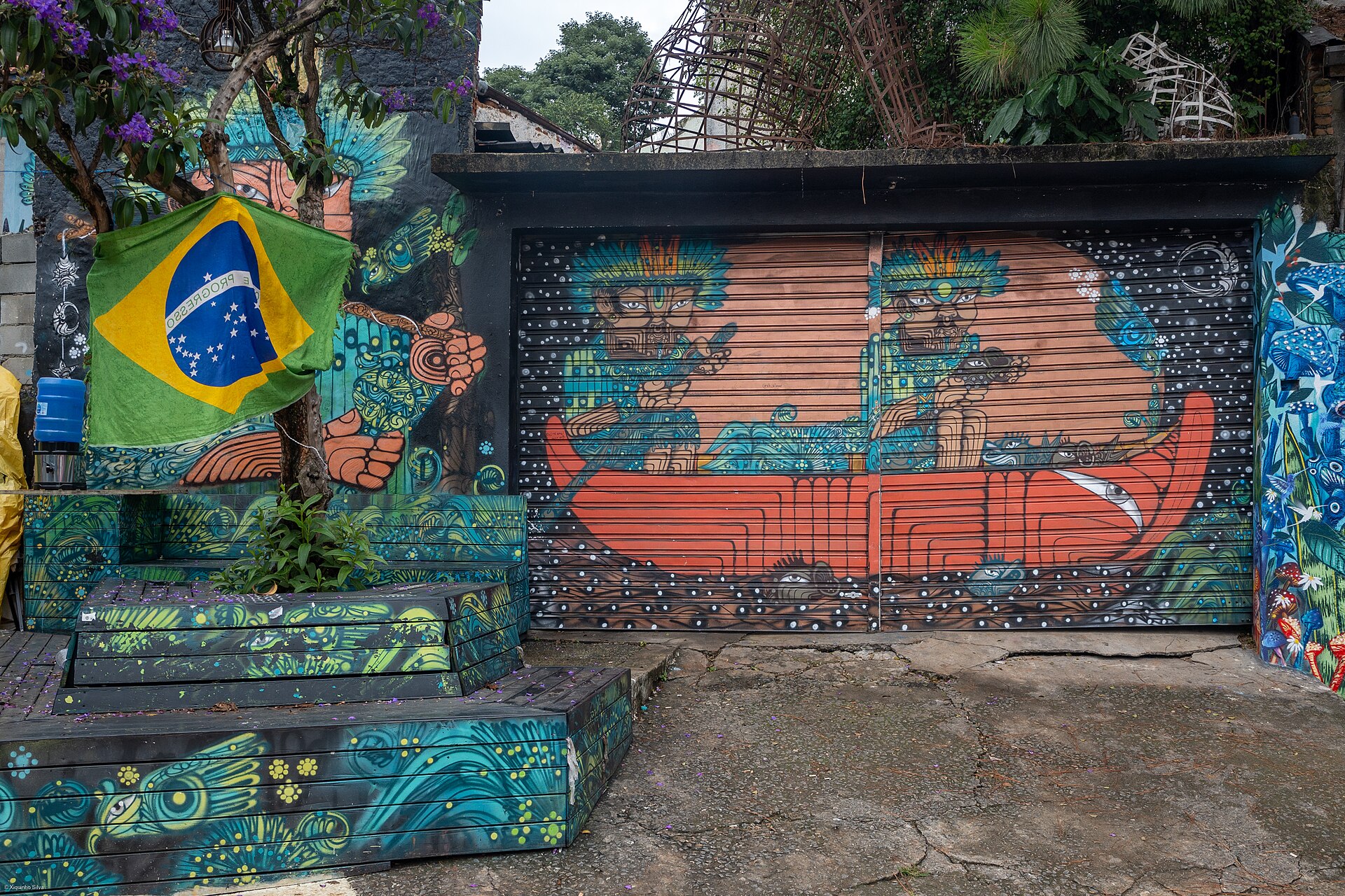 Portão e muros grafitados no Beco do Batman com bandeira do Brasil
